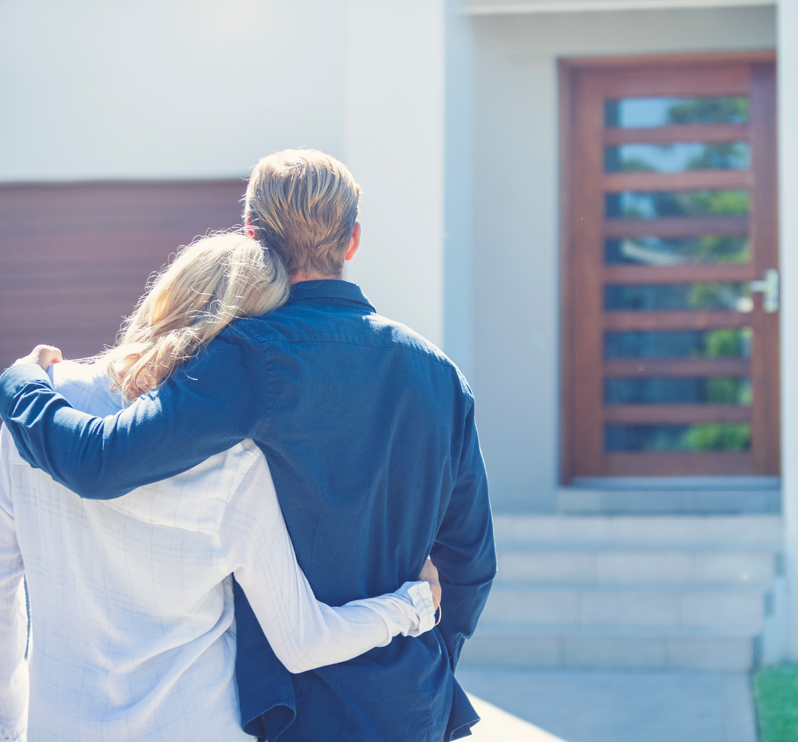 Homeowner couple standing in front of their home