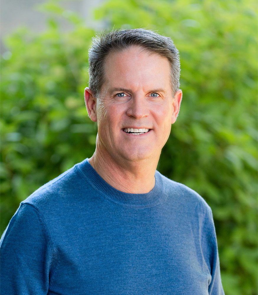 Brian McRae headshot, in blue shirt outside